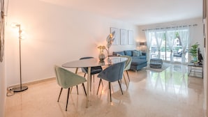 Una sala de estar moderna con una mesa de comedor, sillas, un sofá y una mesita de centro.
