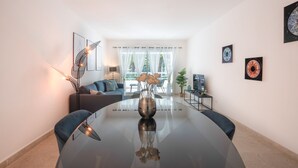 Una sala de estar moderna con una mesa de vidrio, un sofá y una mesa de centro.
