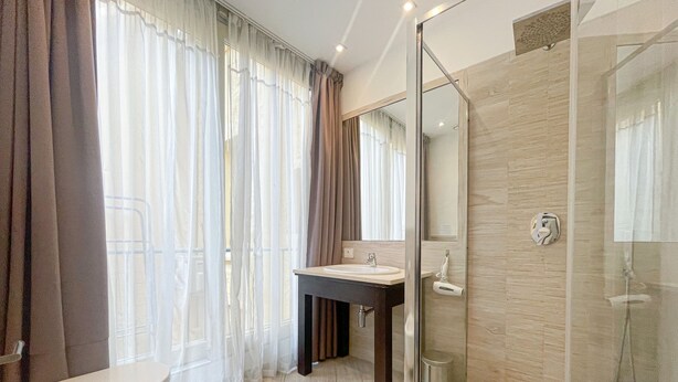 Een moderne badkamer met een bad, wastafel en douchecabine.