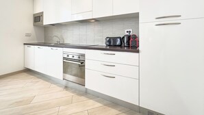 A modern kitchen with white cabinets, a stainless steel oven, a microwave, and a toaster. - 2A Tony Allard in Cannes (Cannes)