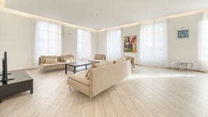 A spacious living room with a large sofa, a coffee table, and a TV stand. - 2A Tony Allard in Cannes (Cannes)