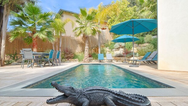 A swimming pool with a crocodile decoration, surrounded by lounge chairs and umbrellas. - 007 Villa Deva in Cannes (Cannes)