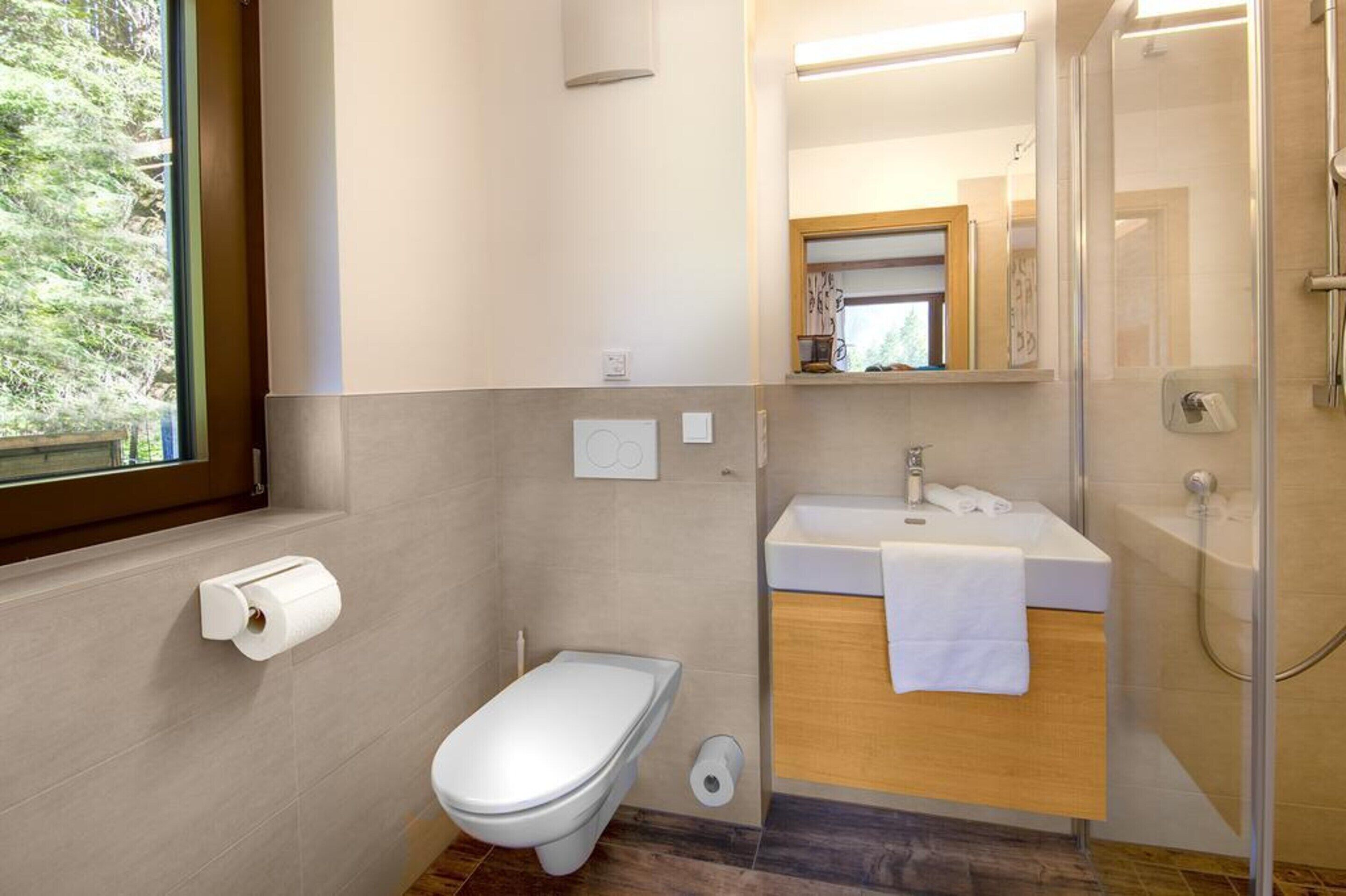 Une salle de bain moderne équipée de toilettes, d’un lavabo et d’une douche.