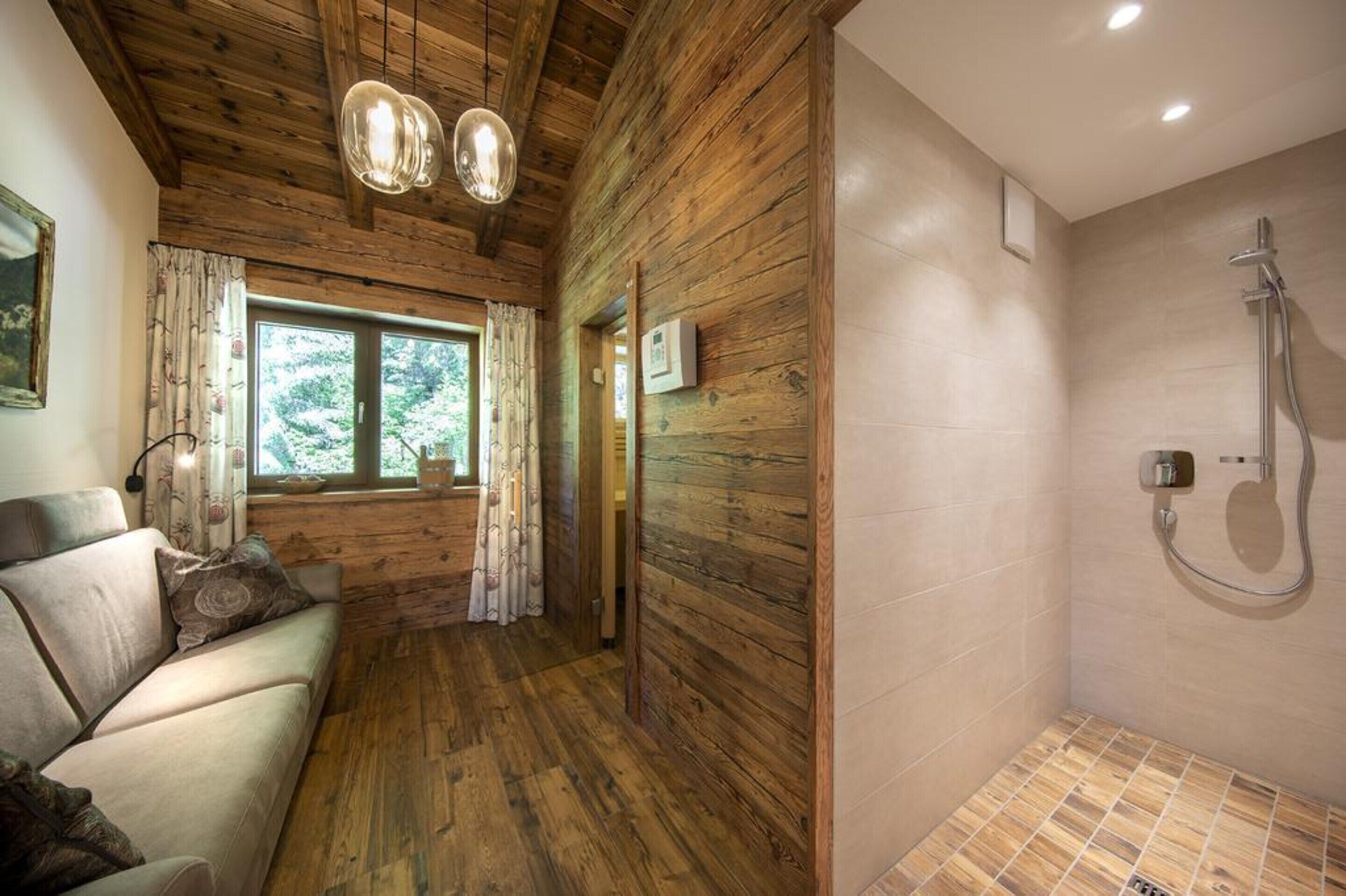 Un intérieur en bois avec un canapé, un espace douche et une fenêtre avec des rideaux.