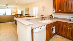A spacious kitchen with wooden cabinets, a dishwasher, and a large island.