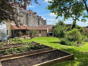 Enjoy a tranquil retreat surrounded by a lush garden with raised vegetable beds and mature trees.