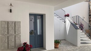 A modern interior with a blue door, a staircase with a stone wall, and potted plants. - Zenia A - large terrace, sea and mountain view, free private garage (Orosei)