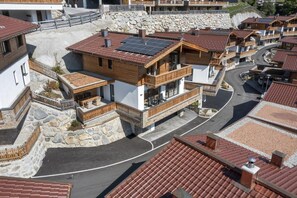 Een modern woongebied met meerlaags huizen voorzien van houten balkons en zonnepanelen.