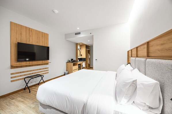 A modern hotel room with a large bed, a mounted TV, and a wooden headboard. - Oro Verde Portoviejo (Portoviejo)