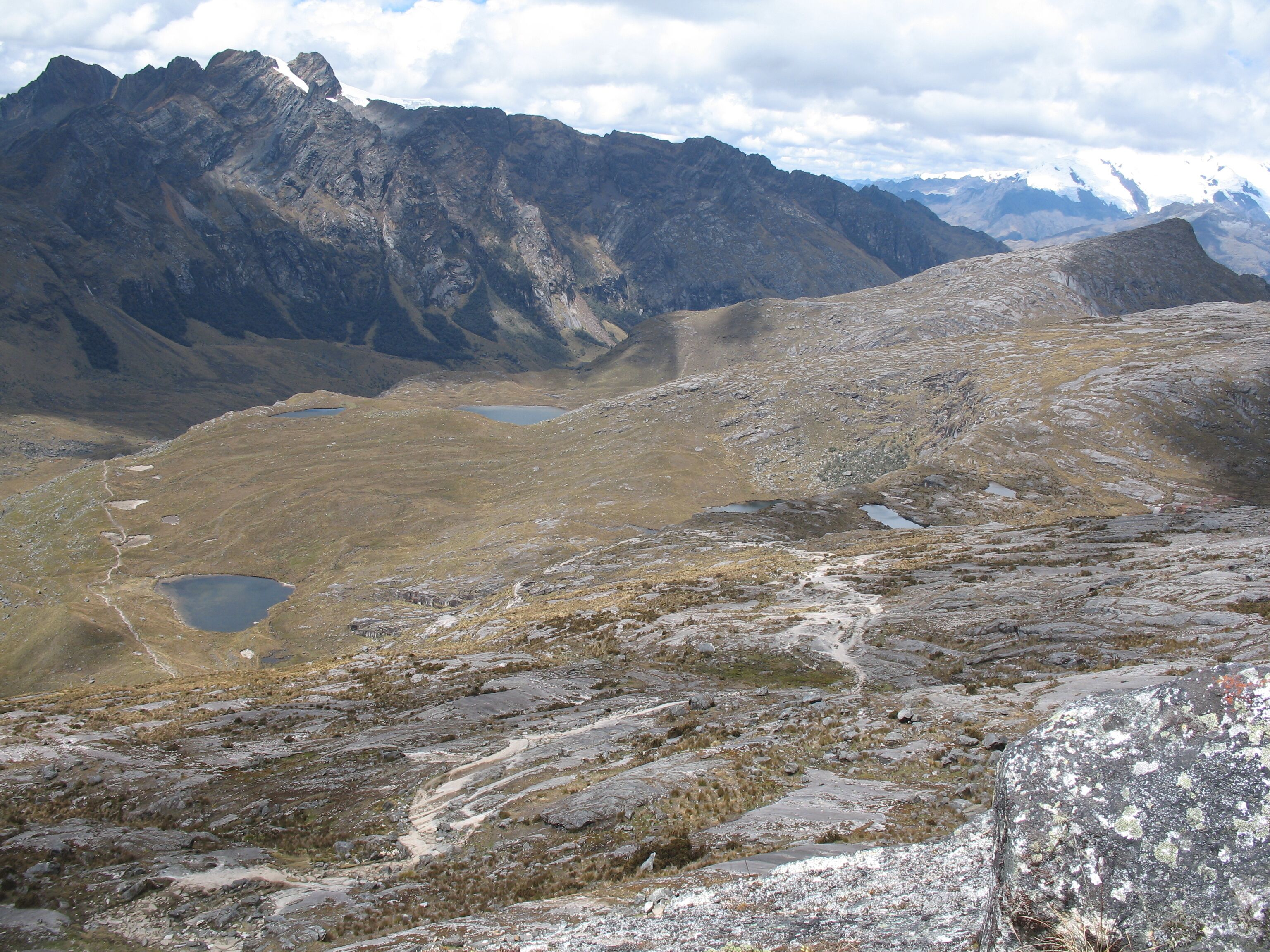 Een bergachtig landschap met rotsachtig terrein en enkele kleine meren.