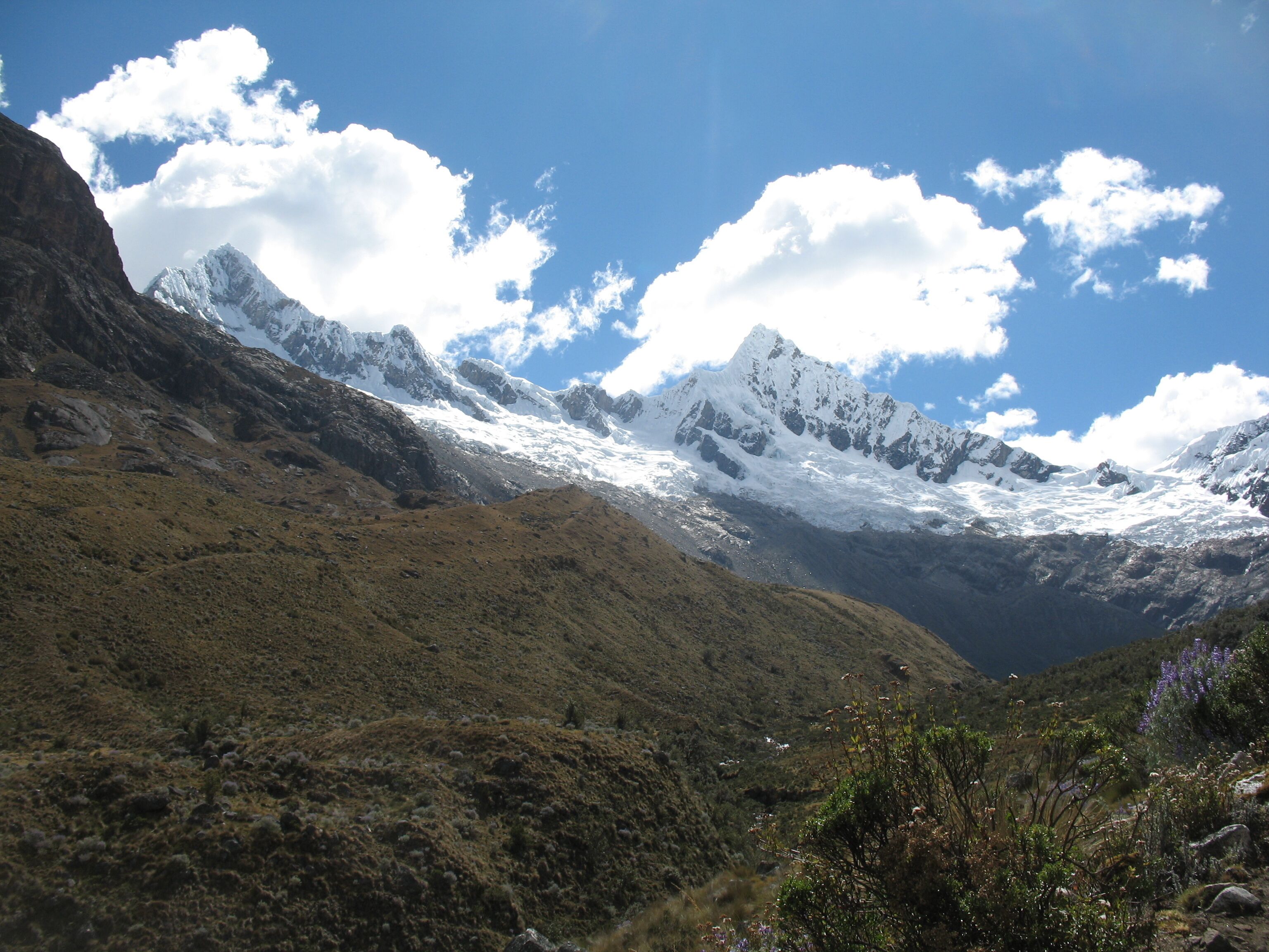 A mountainous landscape with snow-capped peaks and a valley.
