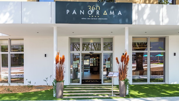 Una entrada de hotel moderna con un letrero que dice "360 PANORAMA HOTEL SPA SKYBAR SEMINAIRES".