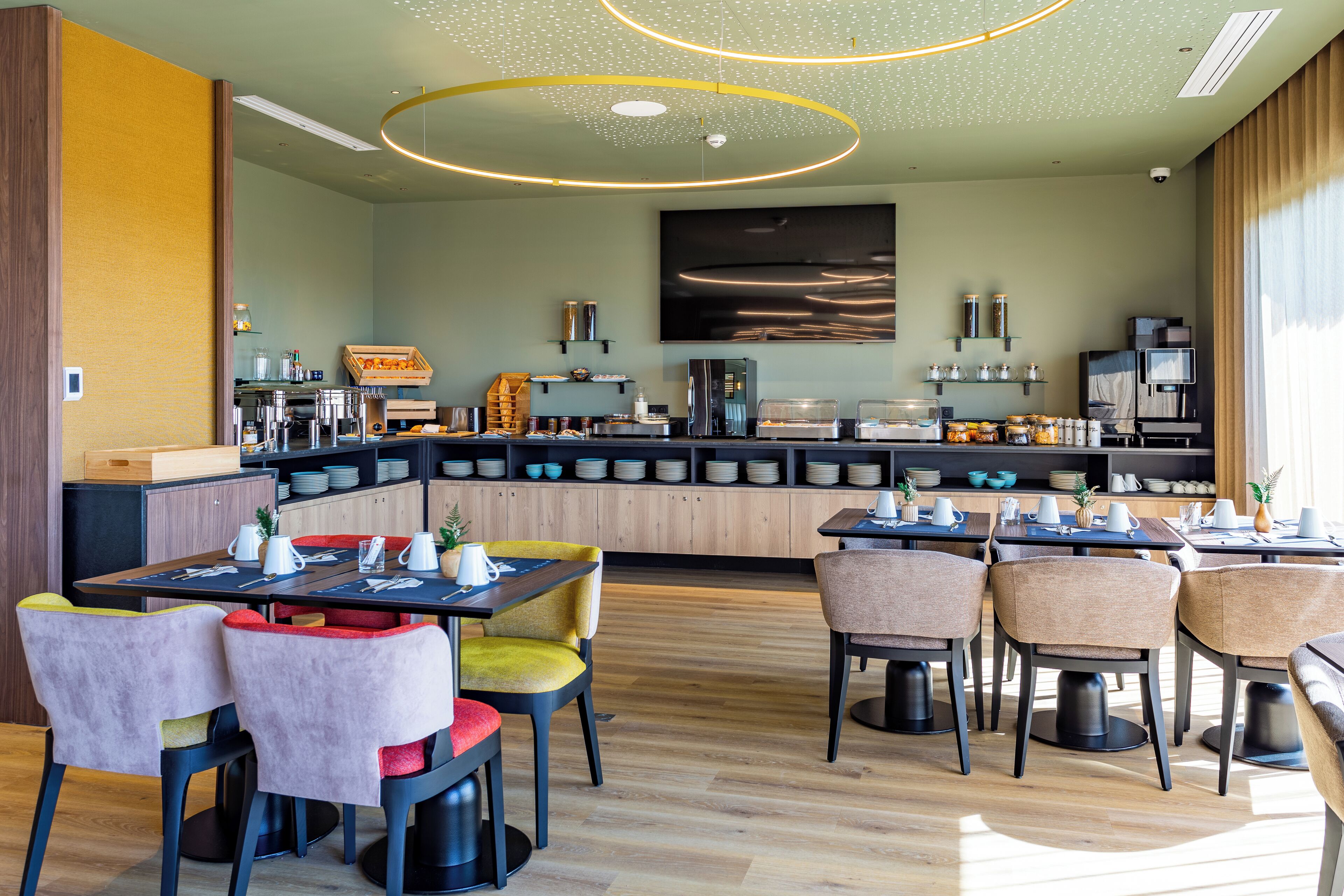 Un comedor moderno con una isla central, disposición de asientos y una cocina al fondo.