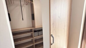 Ein Schrank mit Holzböden und Kleiderstange.
