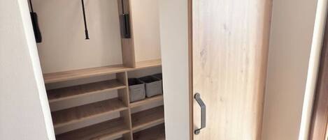 A closet with wooden shelves and hanging space.