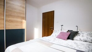 Ein Schlafzimmer mit einem Bett, einem Holzschrank und einer Tür.