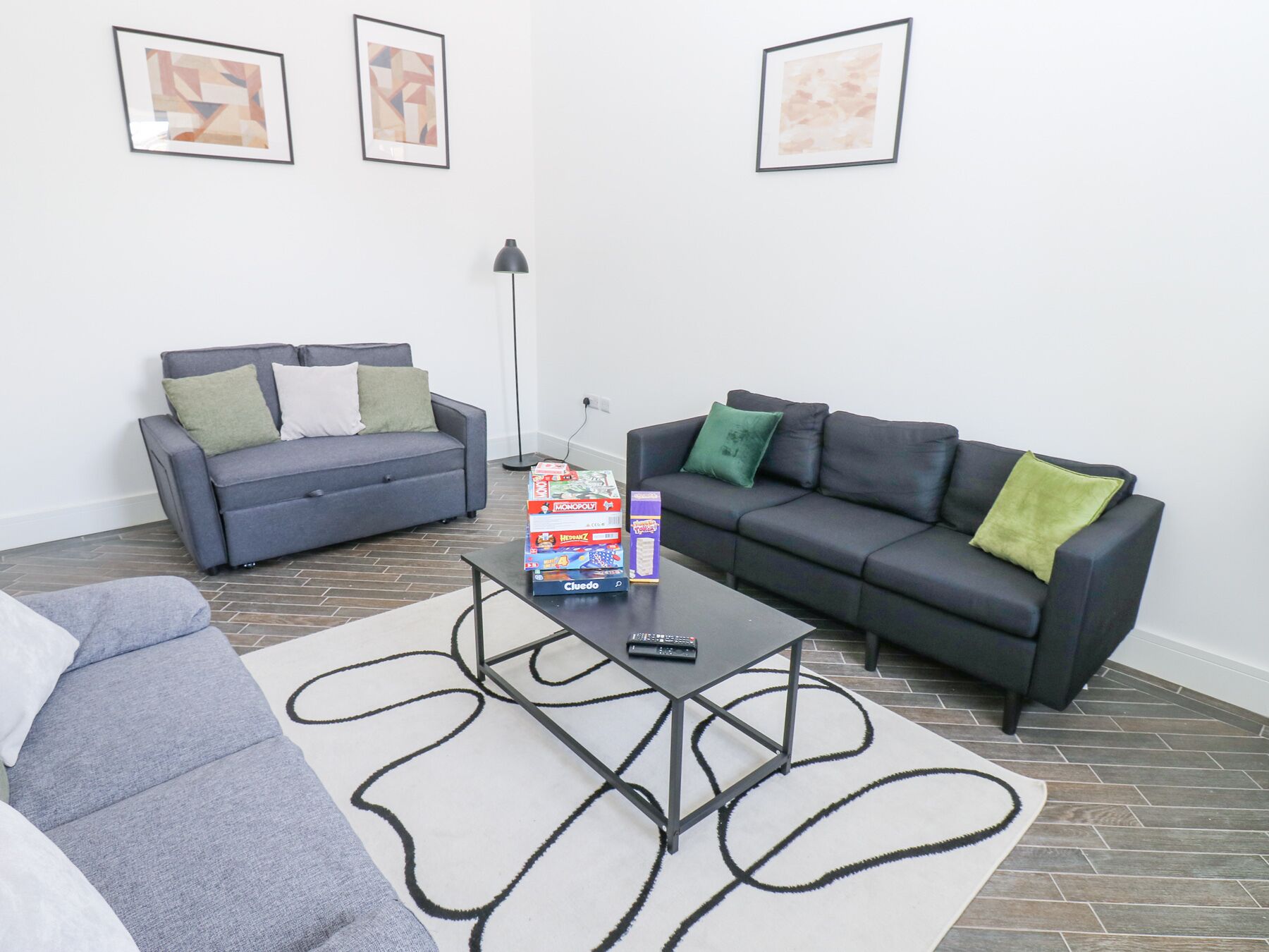 Ein Wohnzimmer mit zwei Sofas, einem Couchtisch und einer Stehlampe.