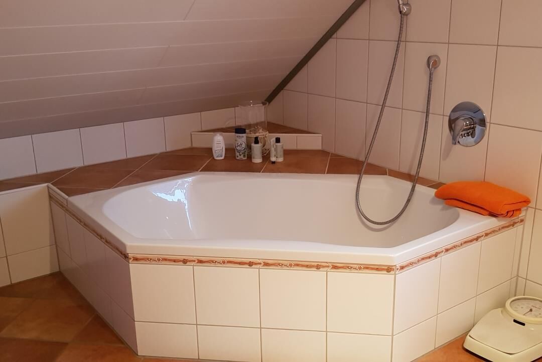 A bathroom with a bathtub, a shower, and a scale.