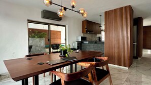 Une cuisine moderne dotée d’un îlot central, d’un coin repas avec une table et des chaises en bois, et d’un luminaire suspendu au-dessus de la table.