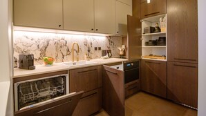 A modern kitchen with wooden cabinets, a marble backsplash, and a built-in dishwasher. - Balcon Champs Elysees (Paris)