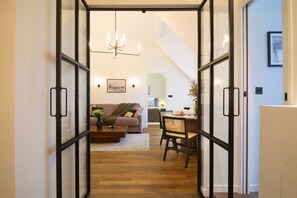 A modern living room with a sofa, coffee table, and dining area. - Balcon Champs Elysees (Paris)