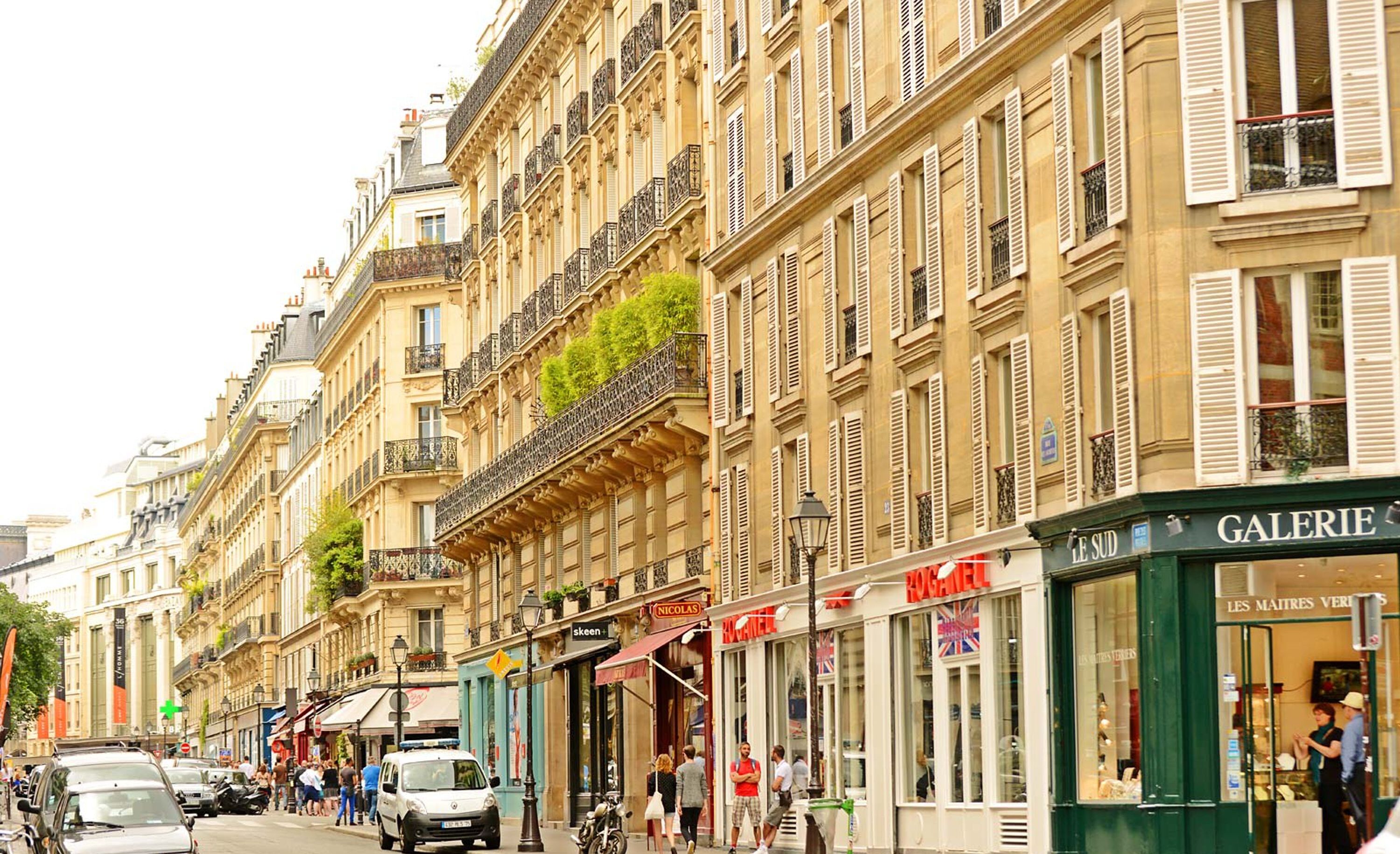 Eine Straße mit Gebäuden, die Geschäfte und Balkone zeigen.