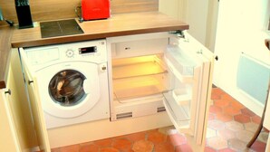 Ein kompakter Waschraum mit Waschmaschine, Trockner und einer kleinen Arbeitsplatte.