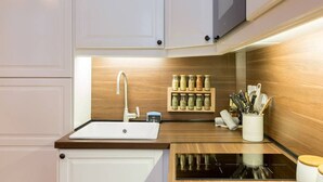 Eine moderne Küche mit weißem Spülbecken, Holz Arbeitsplatte und eingebauten Geräten.