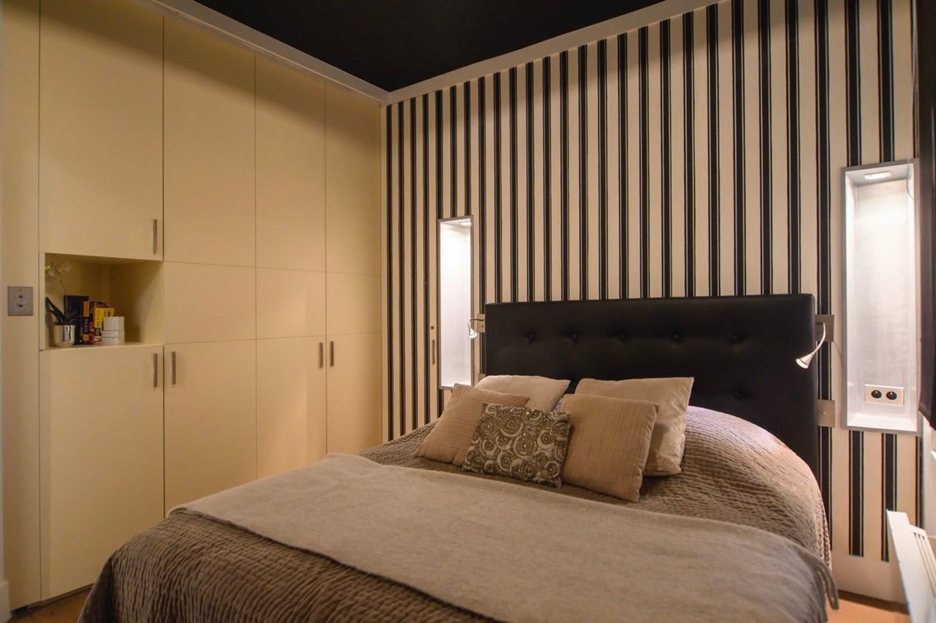 Ein Schlafzimmer mit einem Bett, einem Kopfteil und einem Kleiderschrank.