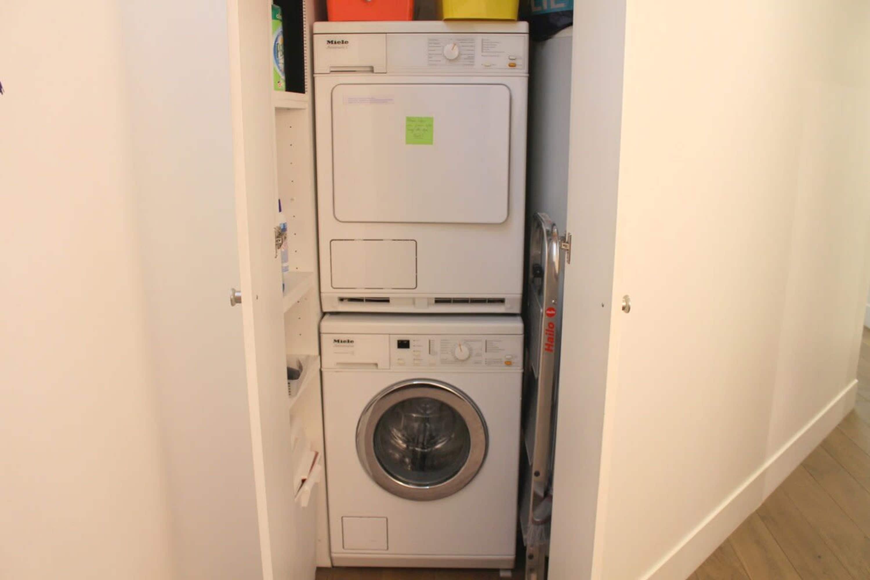 A compact laundry area with a top-loading washing machine and a front-loading dryer.