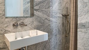A bathroom with a marble sink, a handheld showerhead, and a mirror. - Le Plaisir du Pantheon (Paris)