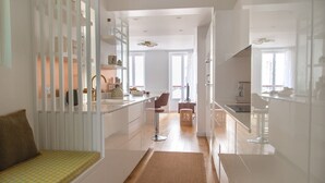 Una cocina moderna con armarios blancos, una isla central y vista al área de comedor.