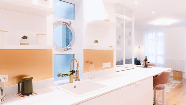 Una cocina moderna con una isla grande, un fregadero y una ventana.