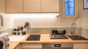 A modern kitchen with a built-in oven, a dishwasher, and a sink. - Villa Montparnasse - 15th arr (Paris)