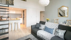 Un appartement moderne comprenant une cuisine, un coin repas et un salon.
