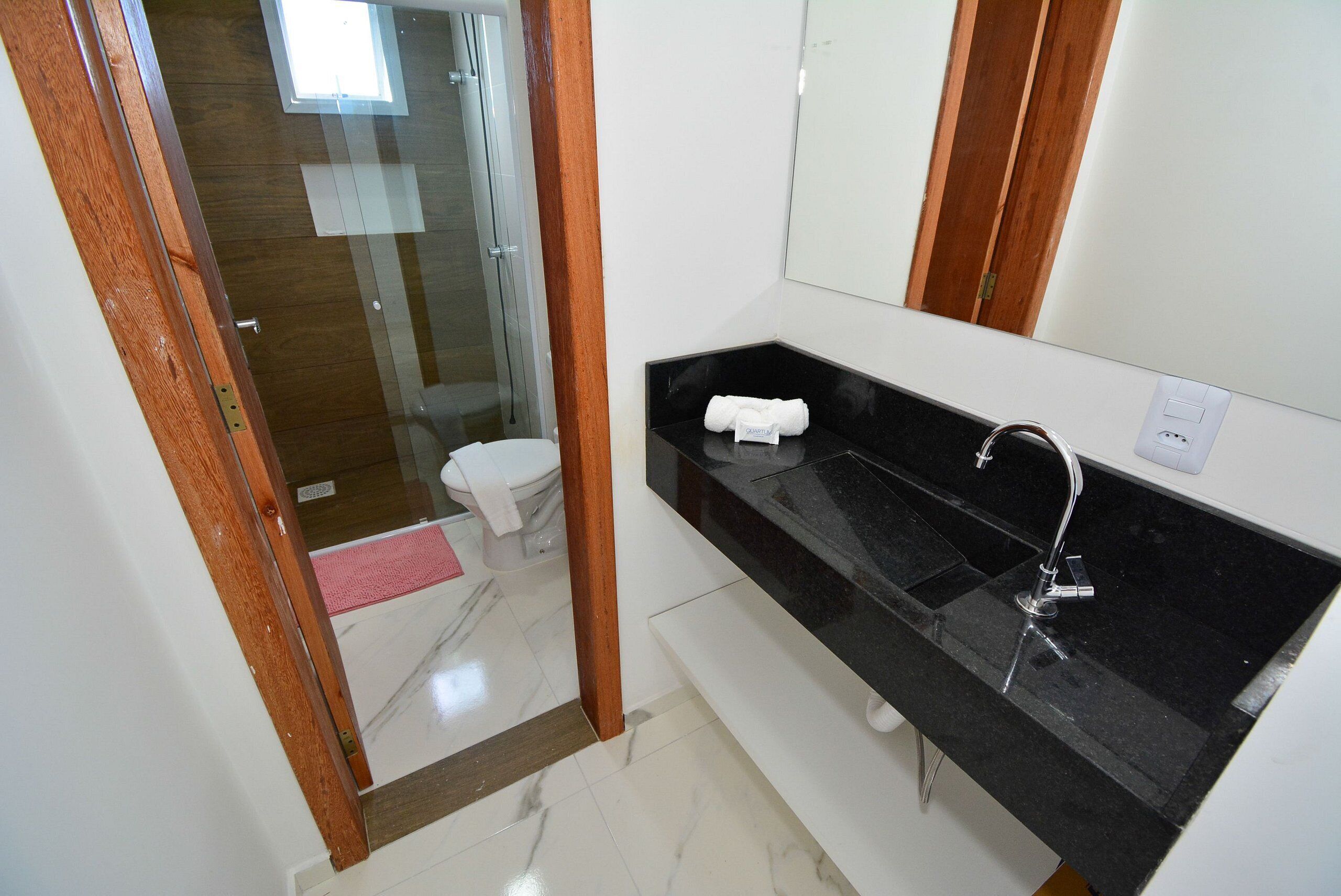 A modern bathroom with a black countertop sink, a mirror, and a glass shower enclosure.