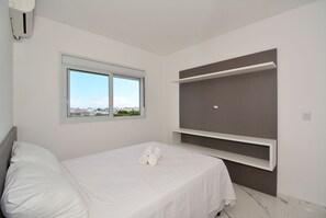 Une chambre à coucher moderne avec un lit, une fenêtre et des étagères intégrées.