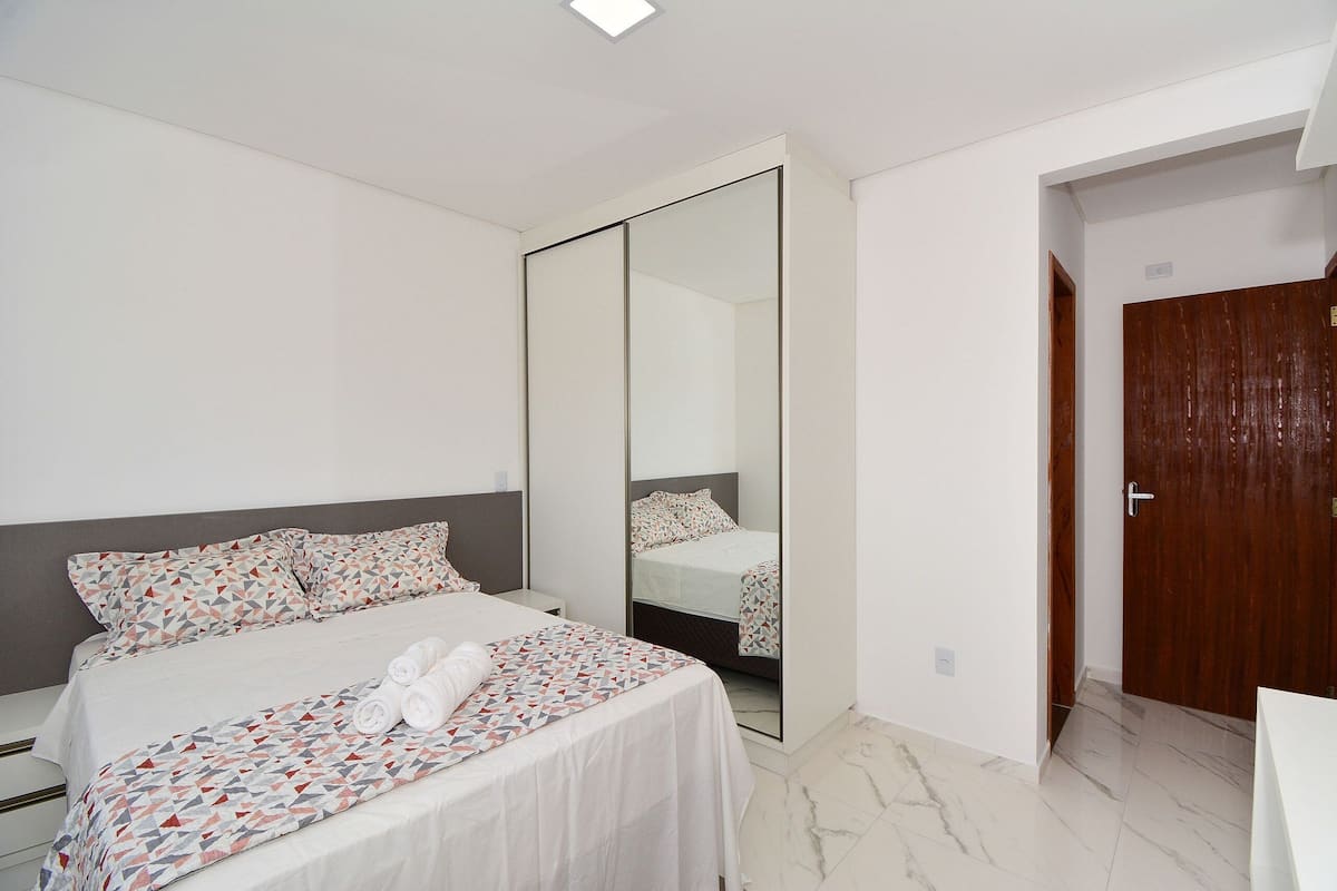 Une chambre à coucher avec un lit, une armoire et une porte.