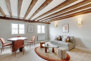 Una habitación con una mesa de comedor, sillas, un sofá y una mesa baja.