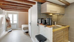 Una cocina compacta con encimera de madera, horno integrado y un lavamanos pequeño.
