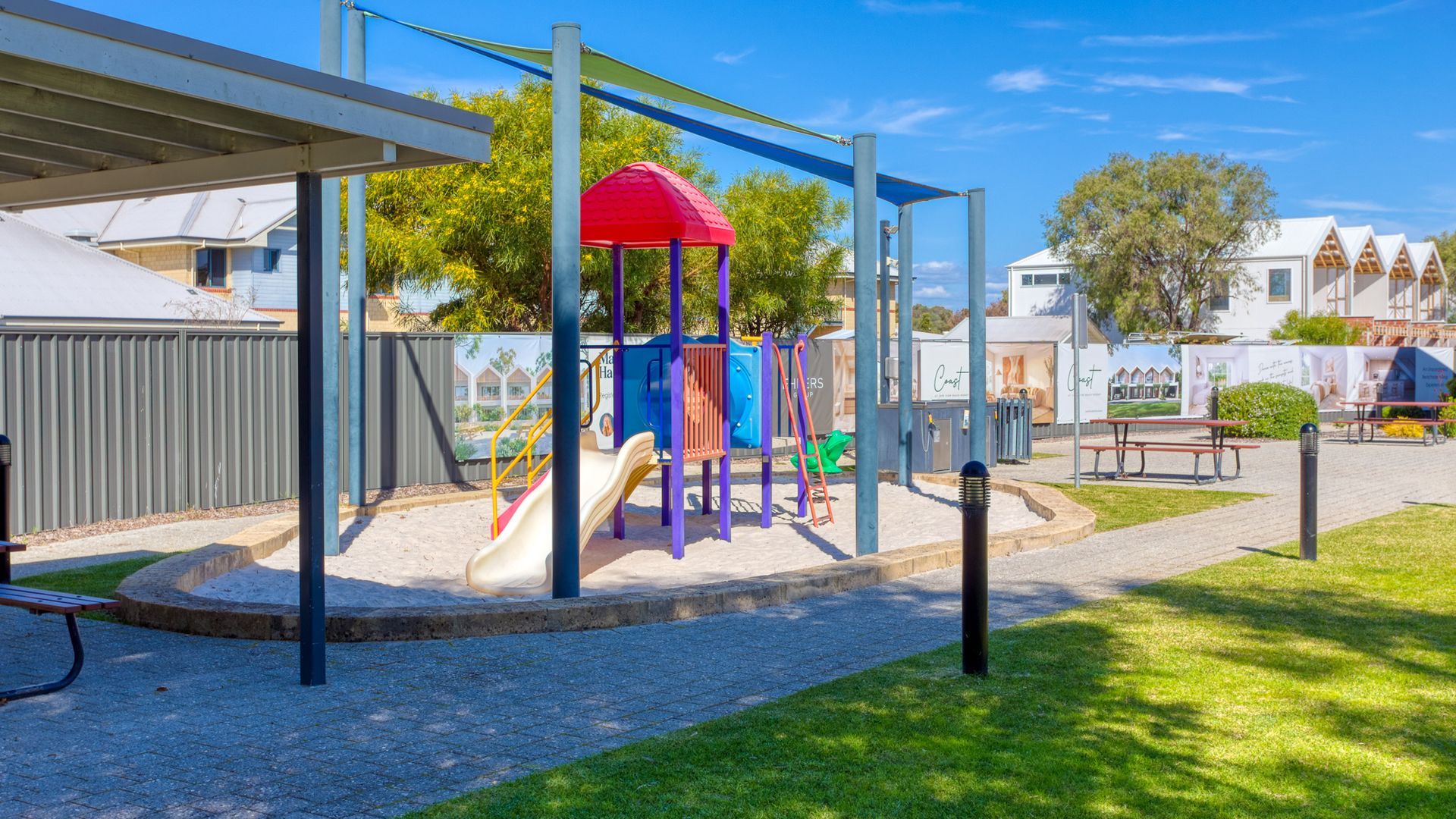 Un parque infantil con tobogán, estructuras para escalar y una zona de juegos cubierta.
