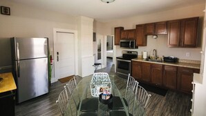 A compact kitchen with a refrigerator, microwave, oven, and wooden cabinets.