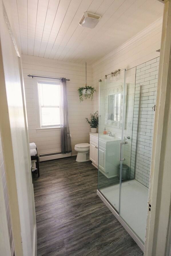 Une salle de bain avec douche, toilettes et lavabo.