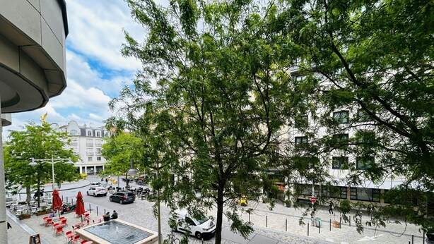 A courtyard with outdoor seating, a fountain, and a tree. - La Suite Buirette Hypercentre (Reims)