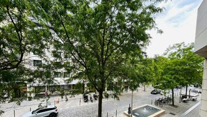 A paved courtyard with a fountain, bicycles, and a white car parked on the street. - La Suite Buirette Hypercentre (Reims)