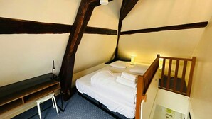 A small, cozy room with a single bed, a desk, and a chair. - La Suite Marie Stuart Hypercentre (Reims)