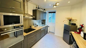 A modern kitchen with stainless steel appliances, a built-in oven, and a microwave. - Le Charmant Carnot Cath Drale (Reims)