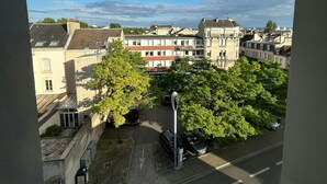 Une vue d’une ville avec ses bâtiments, ses arbres et un ciel dégagé.