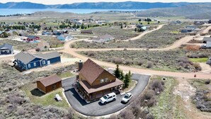 A residential area with houses, a road, and a body of water in the background. - Rustic Mountain Lake Escape (Garden City)