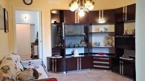 A compact living space with a kitchenette, a dining area, and a seating area with a red sofa. - Vacation home Corrado 2 (Toscana)